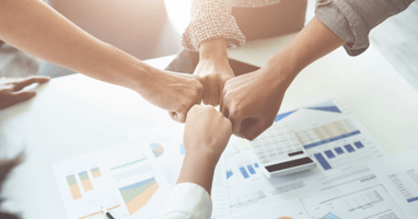group of coworkers fist bumping