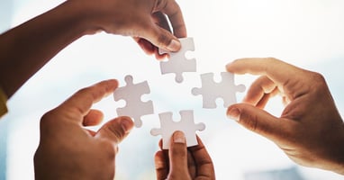 Hands putting puzzle together