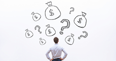 man looking at a wall with money bags and question marks